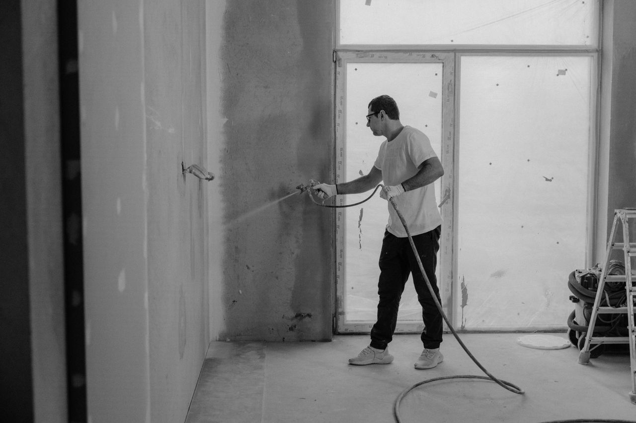 The Art of Drawing Readers In: Your attractive post title goes here A worker paints an interior wall with a spray gun during a renovation project.
