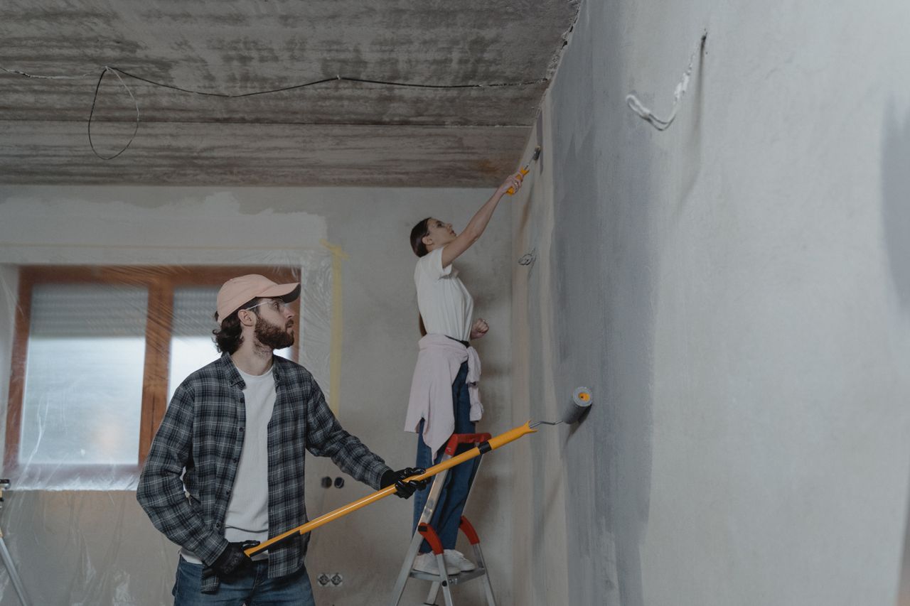Réalisations A couple painting a room together, highlighting teamwork in home renovation.